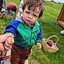child, toddler, outdoor, grass, bench, holding_hand, jacket, brown_pants, sneakers, basket, picnic, person, hair, face, expression, nature, daylight, people, greenery, casual_clothing