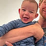 Callan is registered to the contest to win money with this photo: baby, child, smiling, person, adult, holding, blue_clothing, striped, happy, face, arm, hand, portrait, indoor, closeup, skin, head, expression, casual, family