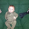 Oliver is registered to the contest to win money with this photo: baby, child, infant, nike, green_clothing, sitting, chair, portrait, face, curious, indoors, young_child, comfortable, soft_texture, one_person, casual_clothing, cute, small_hands, wide_eyes, baby_outfit