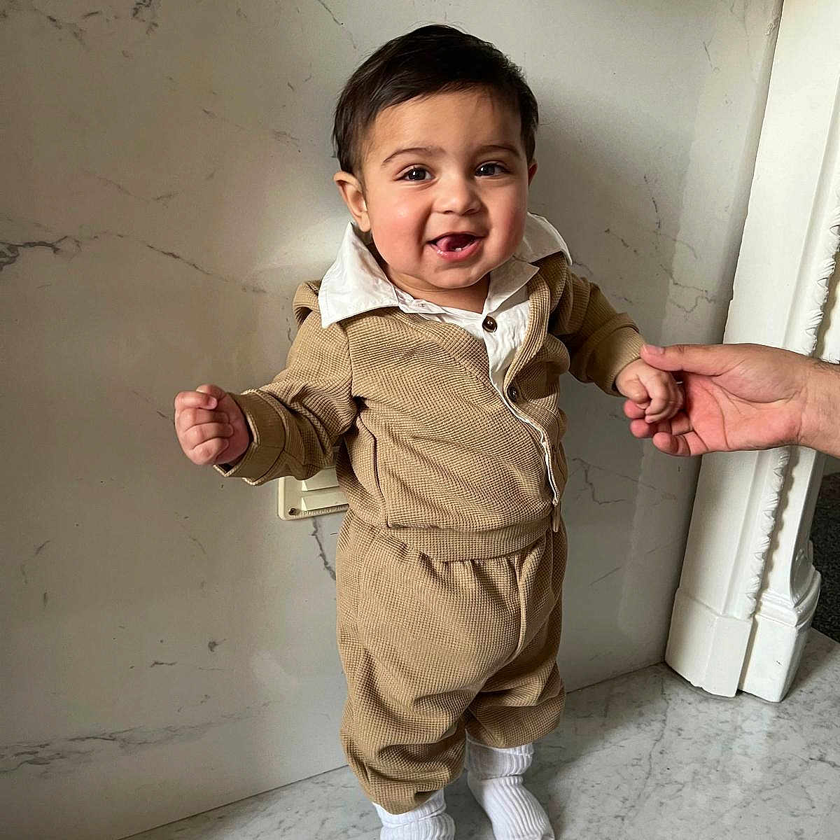 Mikyle Ahmed joined the competition — help win amazing prizes! beige_clothing, child, cute, fashion, hand, happy, holding_hand, home_interior, indoor, marble_floor, marble_wall, person, portrait, smiling, standing, support, toddler, wall, white_socks, young_child