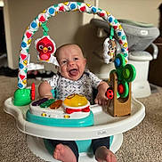 Everett joined the competition — help win amazing prizes! baby, smile, toy, activity_center, carpet, indoor, happy, child, infant, face, feet, clothing, colorful, plastic, furniture, living_room, play, seat, person, cute