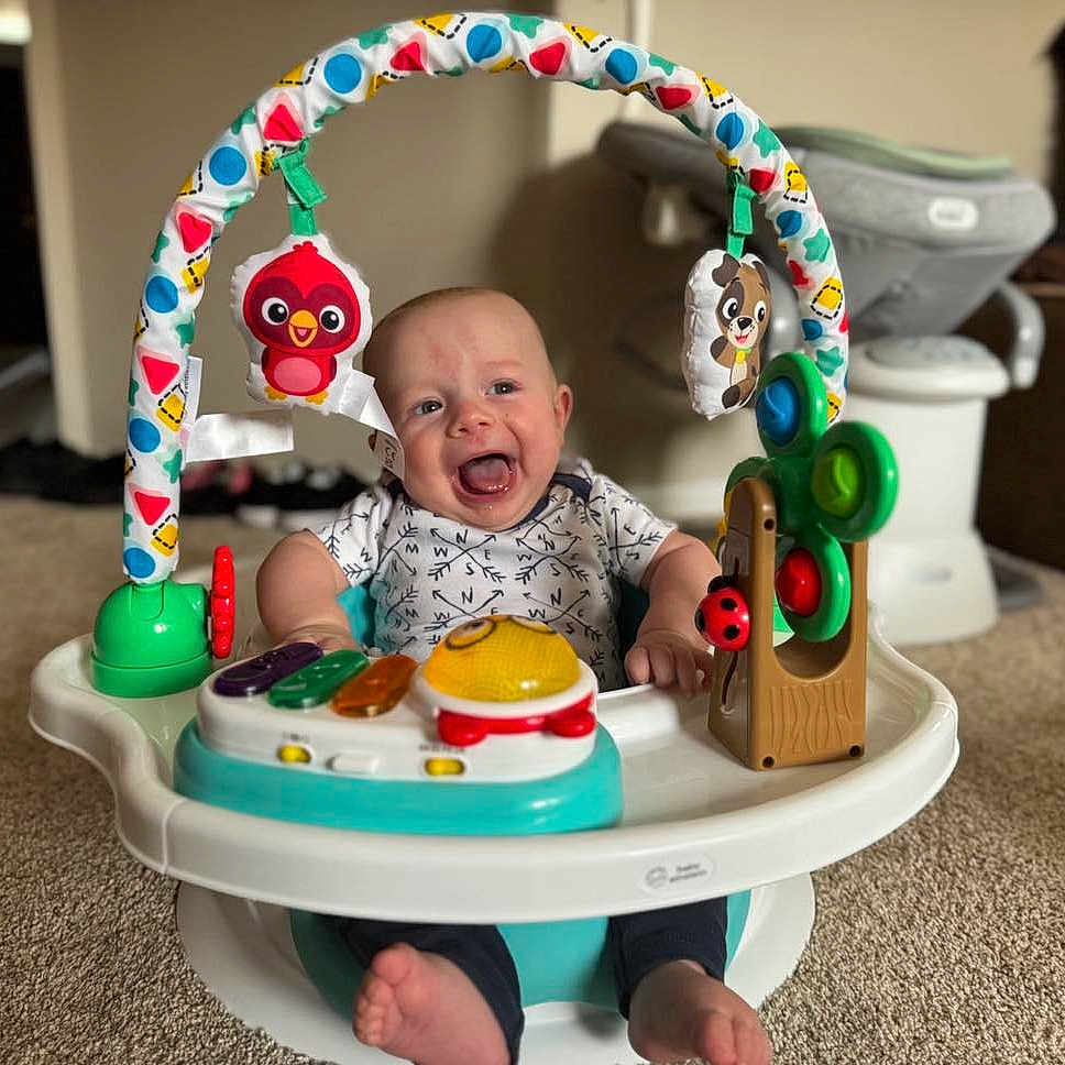 Everett joined the competition — help win amazing prizes! activity_center, baby, carpet, child, clothing, colorful, cute, face, feet, furniture, happy, indoor, infant, living_room, person, plastic, play, seat, smile, toy