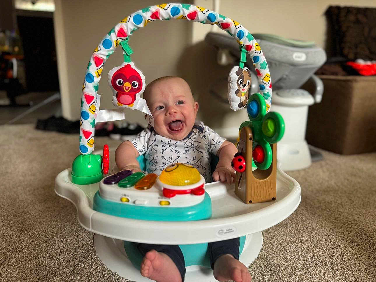 Everett joined the competition — help win amazing prizes! baby, smile, toy, activity_center, carpet, indoor, happy, child, infant, face, feet, clothing, colorful, plastic, furniture, living_room, play, seat, person, cute