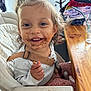 child, chocolate, clothing, cup_with_straw, curtain, face, furniture, hair, happy, high_chair, indoor, kitchen, messy, person, seatbelt, smiling, snack, table, toddler, wooden_table