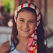 Ghjulia a rejoint le concours — aidez-le/la à gagner de superbes lots ! child, girl, smile, headscarf, portrait, outdoor, face, happy, long_hair, fashion, colorful, young, person, warm_light, casual, headwear, closeup, natural_light, people, summer