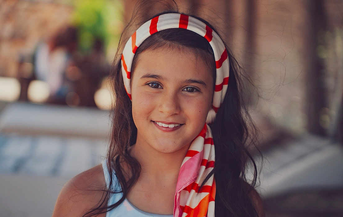 Ghjulia a rejoint le concours — aidez-le/la à gagner de superbes lots ! child, girl, smile, headscarf, portrait, outdoor, face, happy, long_hair, fashion, colorful, young, person, warm_light, casual, headwear, closeup, natural_light, people, summer