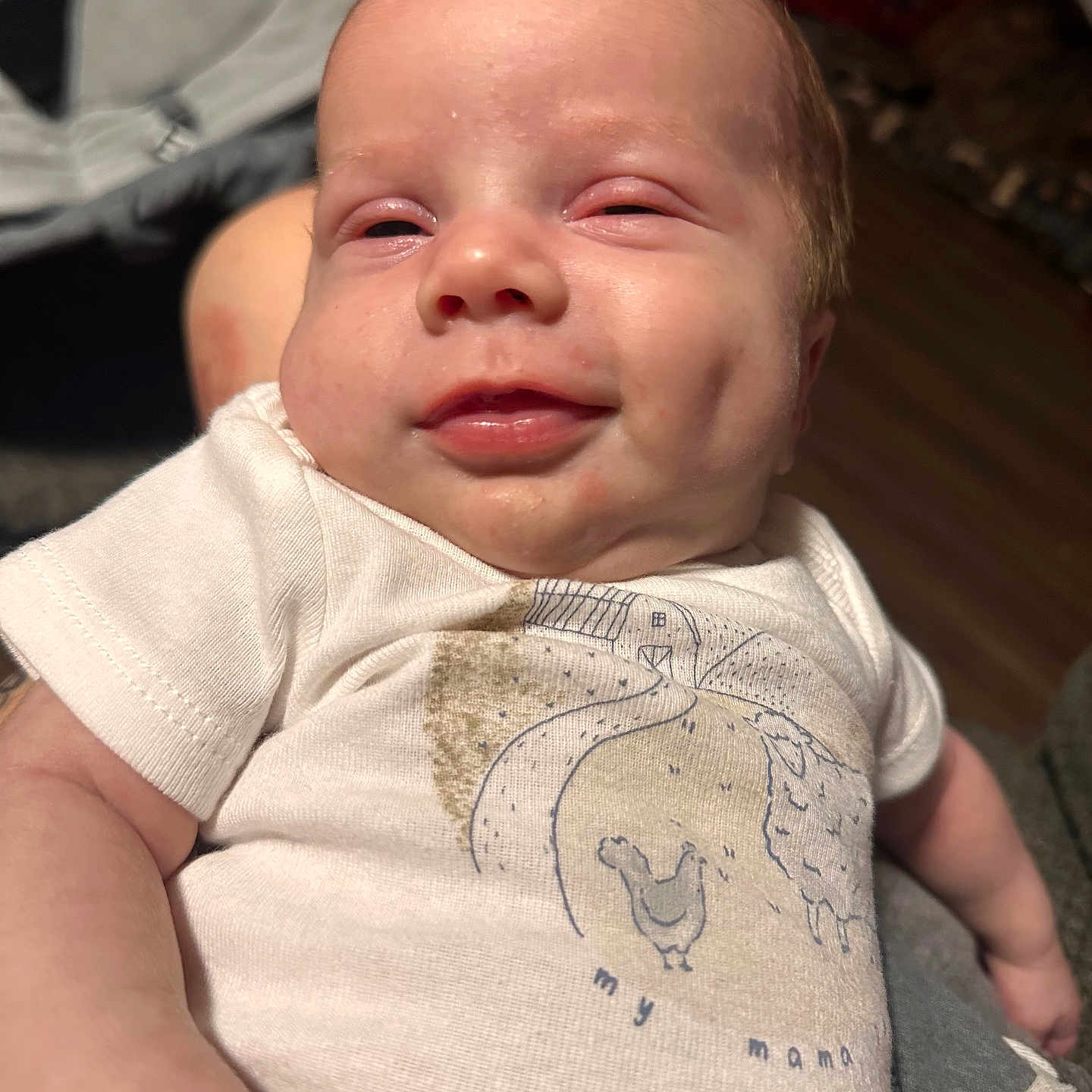 Oaklee is registered to the contest to win money with this photo: arm, baby, closeup, clothing, cute, expression, fabric, face, hand, happy, human, indoor, infant, person, portrait, resting, skin, smile, white_shirt, young_child