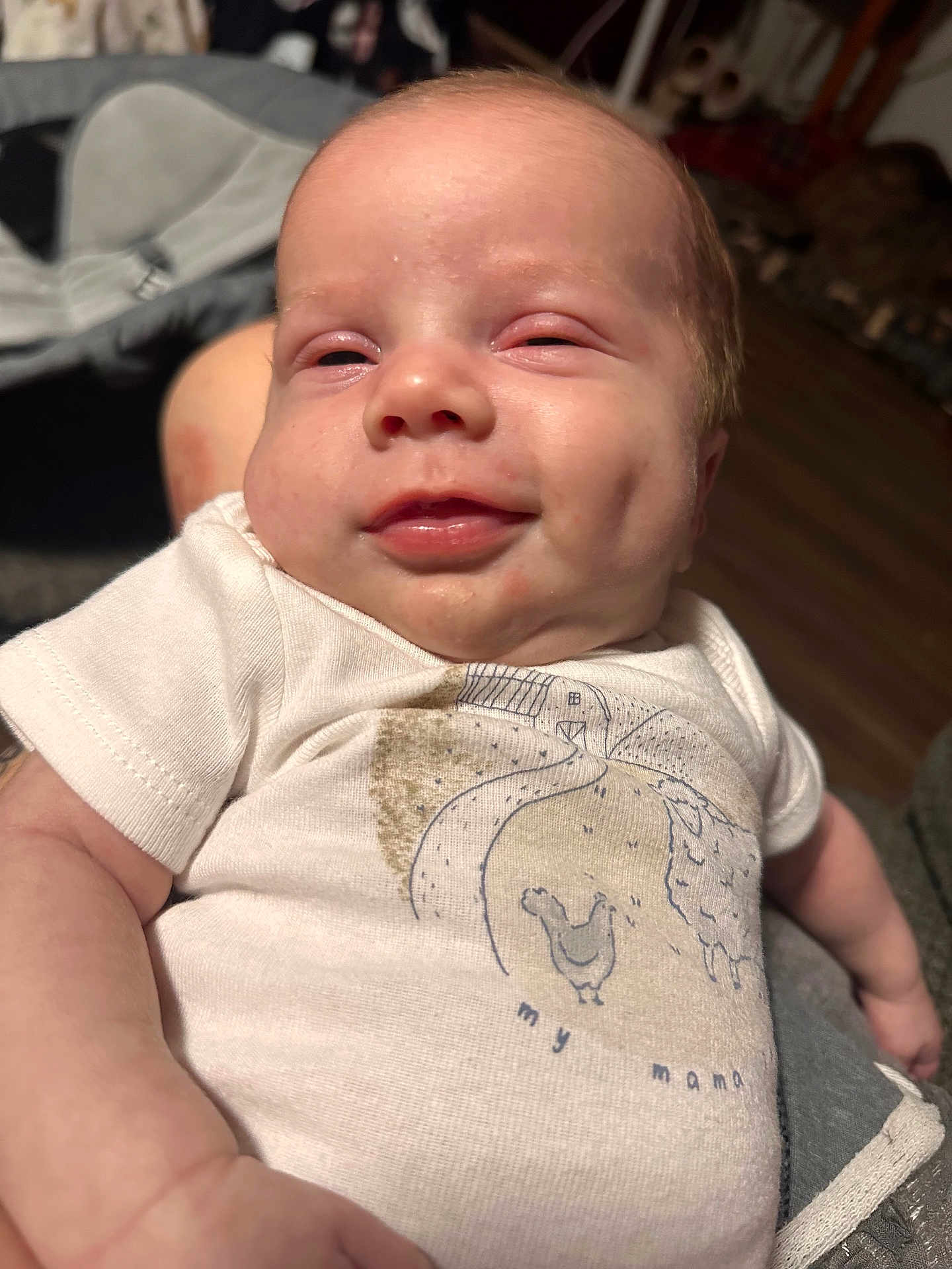 Oaklee is registered to the contest to win money with this photo: baby, infant, smile, face, white_shirt, clothing, person, indoor, closeup, skin, arm, hand, fabric, cute, happy, resting, human, portrait, young_child, expression