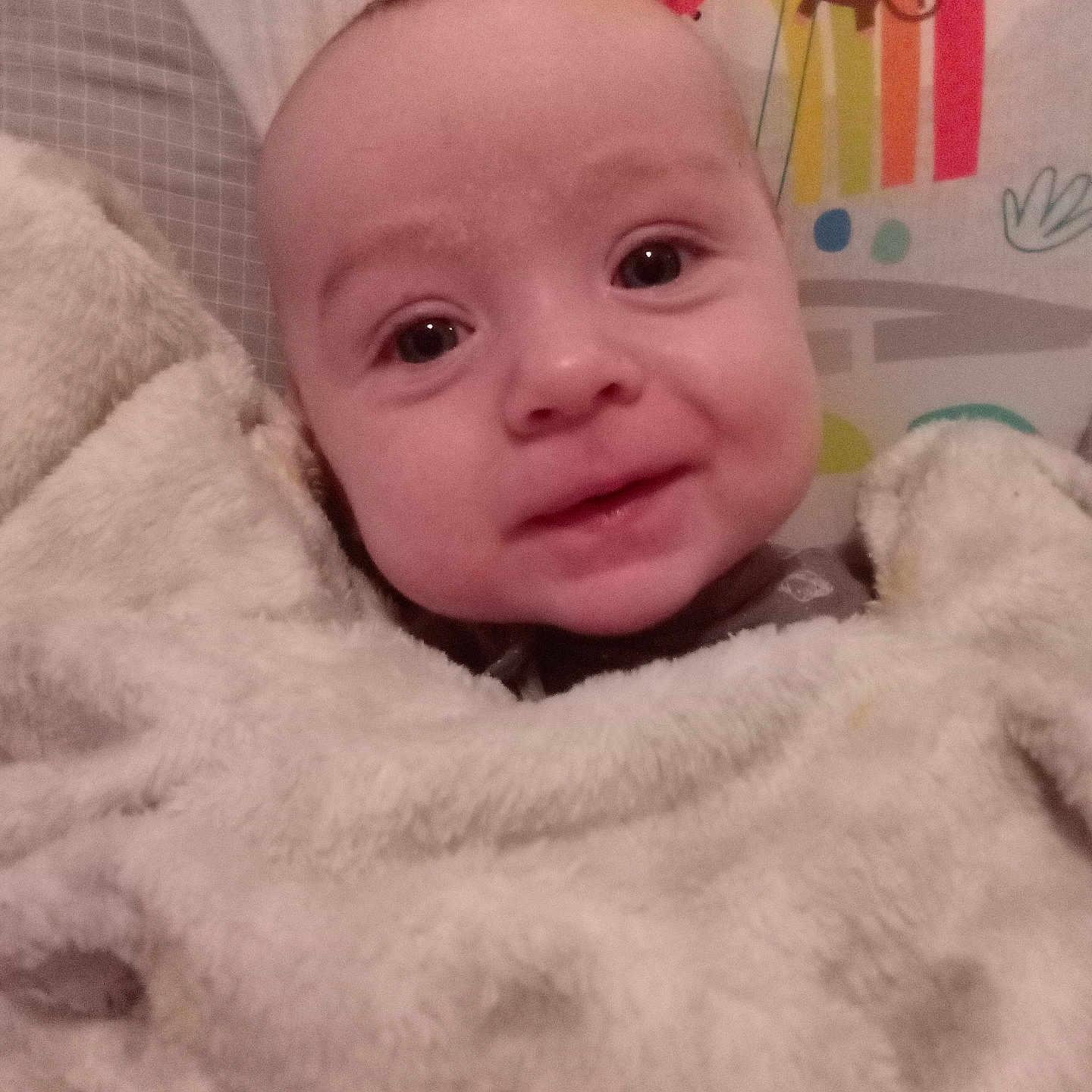 Lincoln is registered to the contest to win money with this photo: baby, blanket, face, smile, child, infant, cute, toy, monkey, rainbow, colorful, soft, warm, indoors, portrait, happy, wrapped, cozy, young, expression