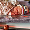 newborn, baby, sleeping, blanket, knitted_hat, hospital_bassinet, infant, cozy, peaceful, bed, sleep, child, cute, warm_light, flower, pattern, rest, wrapped, soft, toddler