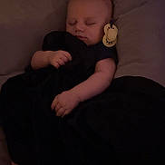 Tazz joined the competition — help win amazing prizes! baby, barefoot, bed, black_clothing, blanket, close_up, cozy, dim_lighting, face, hands, indoors, infant, nap, nursery, pacifier, peaceful, pillow, portrait, resting, sleeping