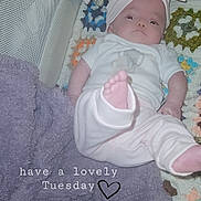 Evelyn is registered to the contest to win money with this photo: baby, infant, blanket, crochet, headband, bow, foot, towel, warning_sign, clothing, lying_down, indoors, cute, soft_toys, pastel_colors, cozy, child, text_overlay, calm, relaxed