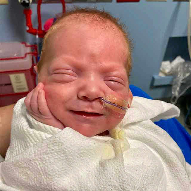 Oscar is registered to the contest to win money with this photo: accessories, architecture, baby, blanket, bodypart, building, clinic, clothing, crying, cushion, earring, face, finger, furniture, glasses, glove, hand, happy, head, homedecor