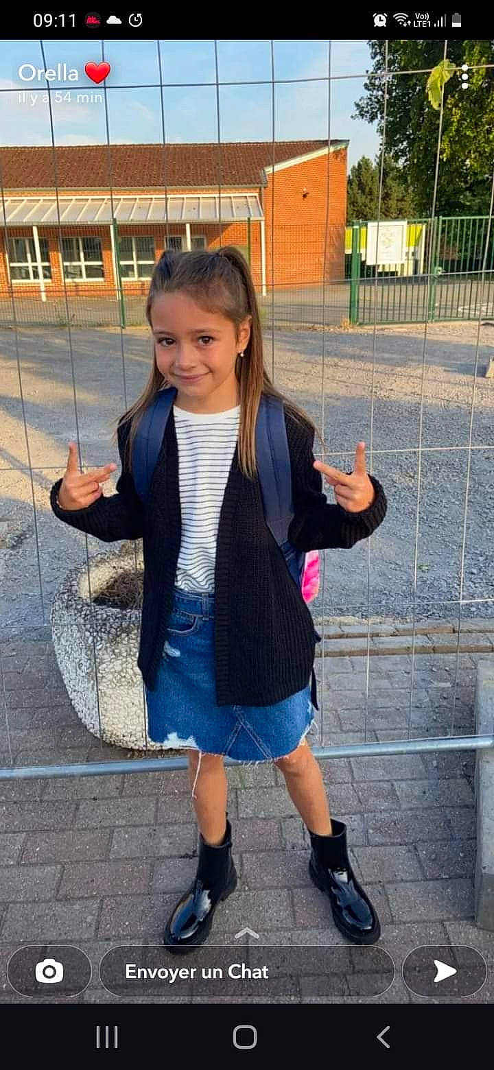 Sheïna participe au concours pour gagner de l'argent avec cette photo : child, cool, denim, electric_blue, fence, footwear, fun, gesture, happy, joy, leisure, neck, pattern, person, recreation, school_uniform, sleeve, smile, standing, thumb