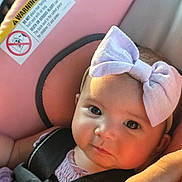 Jaazaniah joined the competition — help win amazing prizes! baby, infant, child, portrait, car_seat, bow, headband, lavender, pink, harness, seatbelt, vehicle, indoors, face, eyes, cheeks, looking_at_camera, sitting, close_up, safety_label
