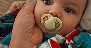Elijah is registered to the contest to win money with this photo: baby, pacifier, hand, blanket, blue_eyes, infant, close_up, skin, nail_polish, warmth, comfort, cute, child, soft, cozy, expression, portrait, sleepy, fingers, resting