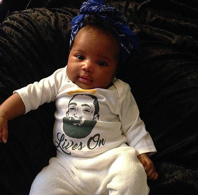 Aura is registered to the contest to win money with this photo: arm, baby, cheek, child, cool, eye, hand, head, human, people, person, product, sitting, skin, sleeve, smile, t_shirt, toddler