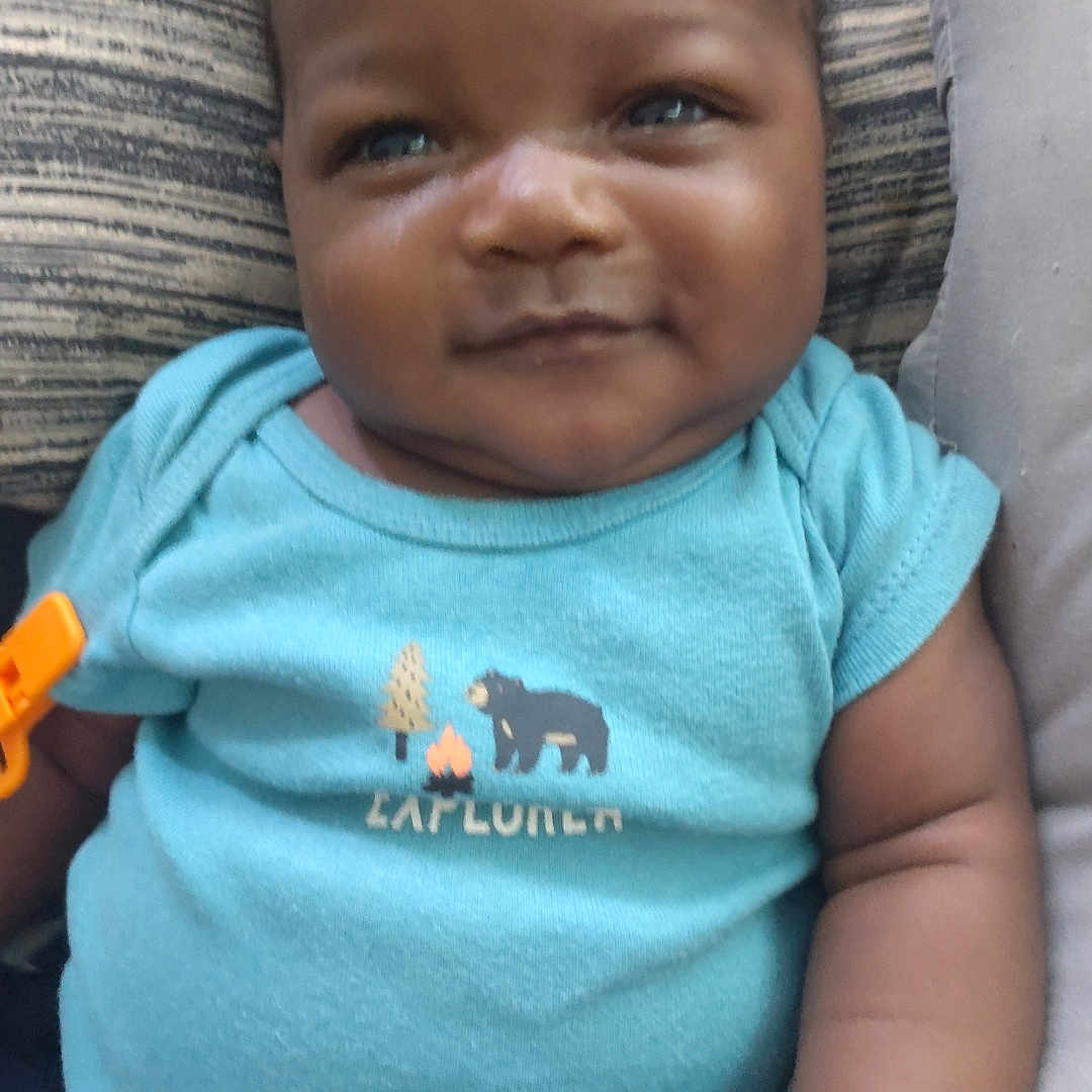 Mah'Kari is registered to the contest to win money with this photo: baby, babylaughing, bodypart, clothing, couch, cushion, face, furniture, happy, head, homedecor, laughing, mouth, person, photography, portrait, sitting, smile, t_shirt, teeth