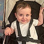 baby, stroller, child, infant, harness, white_clothing, smiling, seat, person, cute, sitting, straps, indoor, happy, young_child, head, face, skin, hand, legs