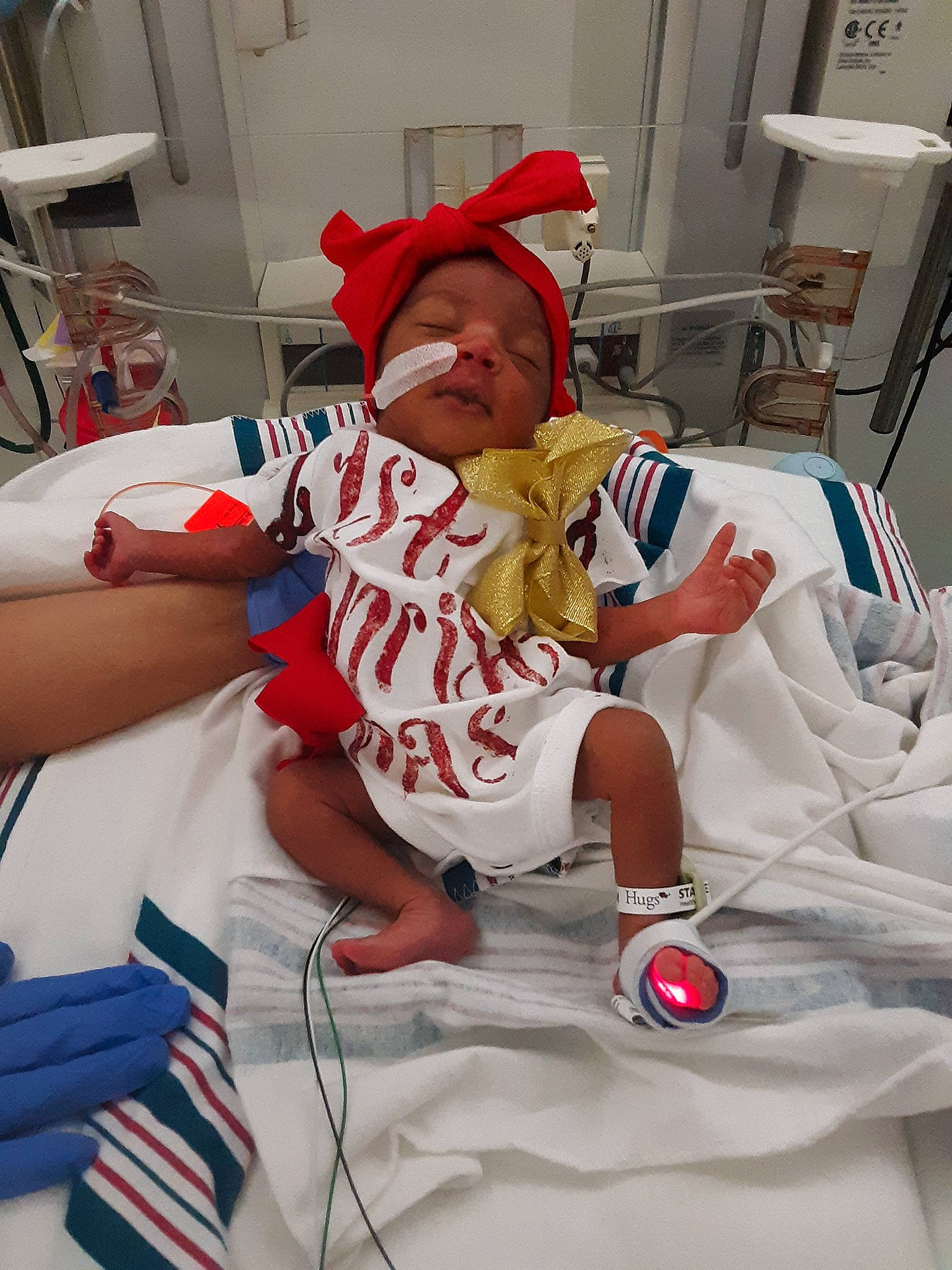 Island is registered to the contest to win money with this photo: baby, baby_toddler_clothing, baseball_cap, cap, carmine, child, christmas, comfort, event, fictional_character, hat, holiday, linens, person, room, sleeve, sock, t_shirt, textile, thigh