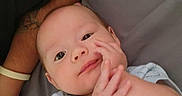 Bartholomew joined the competition — help win amazing prizes! baby, infant, onesie, bed, gray_bedspread, hand, adult_arm, bear_print, cute, lying_down, looking_at_camera, skin, sleepwear, person, human, indoors, soft_lighting, closeup, portrait, child