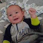 Bartholomew joined the competition — help win amazing prizes! baby, infant, blanket, clothing, cushion, face, hand, indoors, laying_down, person, portrait, smile, toddler, wearing_long_sleeves, wearing_pajamas, cozy, cute, child, happy, resting