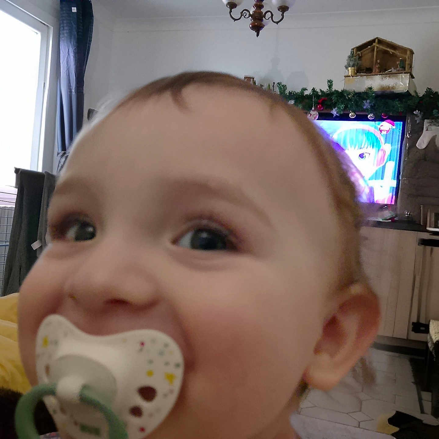 Fiurenzu a rejoint le concours — aidez-le/la à gagner de superbes lots ! animated_character, bench, blanket, cabinet, child, closeup, curtains, face, floor, furniture, holiday_decorations, home, indoors, living_room, pacifier, person, smiling, television, toddler, window