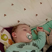 Fiurenzu participe au concours pour gagner de l'argent avec cette photo : baby, sleeping, pacifier, pillow, blanket, onesie, animal_print, toy, bed, heart_pattern, child, infant, cozy, cute, soft, rest, peaceful, indoor, closeup, portrait