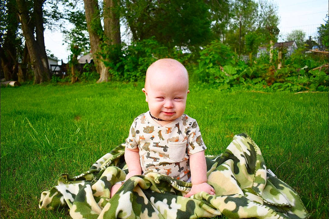 Chaise joined the competition — help win amazing prizes! baby, baby_toddler_clothing, child, fun, garden, grass, grass_family, green, happy, lawn, leisure, military_camouflage, people_in_nature, person, plant, recreation, sitting, sky, smile, toddler