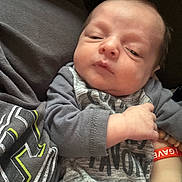 Daymian joined the competition — help win amazing prizes! baby, infant, child, clothing, hand, bracelet, sleepsuit, person, skin, face, expression, newborn, cute, indoors, portrait, babywear, resting, wrinkled_skin, casual, soft_lighting