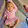 baby, infant, child, pink_robe, hood, couch, sofa, blanket, indoor, foot, hand, face, eyes, expression, comfortable, soft_texture, home, relaxed, toddler, cute