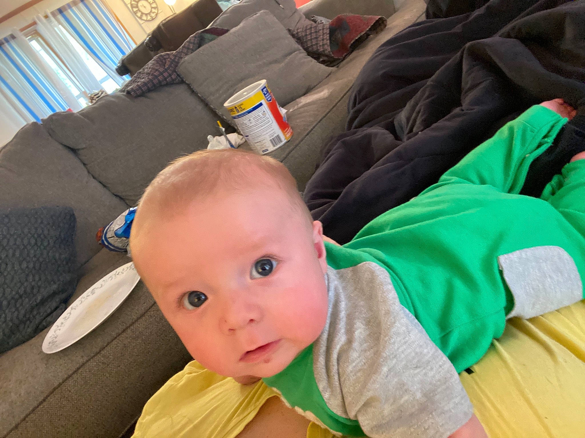 Atticus is registered to the contest to win money with this photo: armrest, auto_part, baby, baby_products, baby_safety, baby_toddler_clothing, car_seat, chair, child, comfort, couch, flooring, living_room, person, pillow, room, sitting, throw_pillow, toddler, window