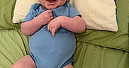 Lucas joined the competition — help win amazing prizes! baby, infant, smiling, blue_onesie, pillow, bed, green_bedspread, happy, face, skin, head, arms, legs, person, child, cute, indoors, lying_down, young, human