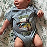 Lucas joined the competition — help win amazing prizes! baby, infant, onesie, clothing, fish_graphic, blanket, pattern, leaf_pattern, cute, child, smiling, lying_down, indoors, soft_light, skin, head, arms, legs, casual, playful