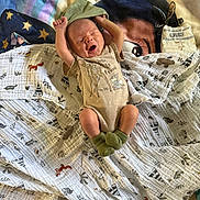 Lucas is registered to the contest to win money with this photo: baby, newborn, yawning, onesie, blanket, muslin_cloth, animal_print, bambi, green_socks, stretching, infant, cute, sleepy, lying_down, cozy, soft_texture, colorful, indoor, child, adorable