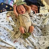 baby, newborn, yawning, onesie, blanket, muslin_cloth, animal_print, bambi, green_socks, stretching, infant, cute, sleepy, lying_down, cozy, soft_texture, colorful, indoor, child, adorable