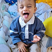 Jake participe au concours pour gagner de l'argent avec cette photo : toddler, child, baby, crib, plush_toy, blanket, smile, tongue_out, happy, indoor, clothing, pants, socks, bed, soft_toys, playful, cute, person, head, face