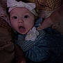 Viviana is registered to the contest to win money with this photo: baby, blanket, bow, child, clothing, cute, dress, expression, eyes, fabric, face, flower, hand, headband, indoor, infant, mouth, person, portrait, surprised