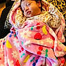 adorable, baby, blanket, closed_eyes, clothing, cozy, cushion, face, floral_pattern, fruit_pattern, indoors, infant, leopard_print, newborn, peaceful, photography, pink_blanket, portrait, resting, sleeping