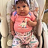 baby, bow, chair, child, cushion, cute, dark_hair, dinosaur, dinosaur_print, headband, high_chair, home, indoor, infant, patterned_clothing, photograph, pink_clothing, portrait, sitting, wide_eyed