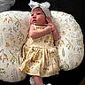 Jaylianette joined the competition — help win amazing prizes! baby, baby_fashion, black_background, bow_headband, child, closeup, cushion, cute, dress, indoors, infant, lying_down, patterned_clothing, pillow, portrait, raised_hand, sleepwear, soft_lighting, teddy_bears, white_shoes