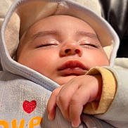 Musa is registered to the contest to win money with this photo: baby, sleeping, hood, hand, face, cozy, infant, soft_lighting, closeup, peaceful, cute, child, clothing, nap, indoor, portrait, warm, adorable, resting, love