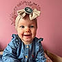 Soline a rejoint le concours — aidez-le/la à gagner de superbes lots ! baby, infant, child, headband, bow, chanel_logo, denim_dress, pink_wall, floral_wreath, smiling, portrait, indoor, bed, blanket, ruffles, wooden_bedframe, buttons, blue_eyes, hand, cute
