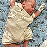newborn, baby, sleeping, infant, portrait, overalls, striped_clothing, mittens, blanket, blue_blanket, lying_down, peaceful, indoors, close_up, face, eyes_closed, arms_raised, bare_feet, patterned_background, cozy