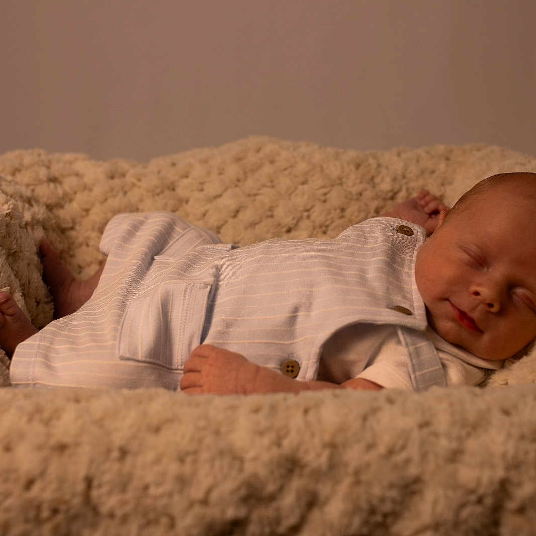Jaxon is registered to the contest to win money with this photo: baby, bed, bedroom, blanket, bodypart, couch, cushion, face, finger, furniture, hand, head, homedecor, indoors, newborn, person, photography, portrait, quilt, sleeping