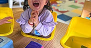 Arabella joined the competition — help win amazing prizes! child, toddler, happy, smiling, indoor, classroom, colorful, toy, soft_toy, table, wooden_table, yellow_chair, person, face, play, cute, young_child, clothing, hair, furniture