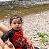 toddler, child, swimsuit, lego, river, water, rocks, adult_hand, outdoor, nature, curious, wet_hair, people, summer, playful, holding, portrait, baby, person, casual