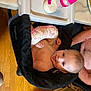 baby, child, high_chair, bottle, milk, tongue_out, pillow, black_fabric, wood_floor, marble_countertop, arm, shirtless, cute, happy, indoor, feeding, infant, person, table, kitchen
