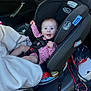 baby, car_seat, car_interior, smiling, child, pink_clothing, blanket, safety_harness, seat, window, door, seatbelt, happy, infant, rear_facing, vehicle, child_safety, graco, polka_dot, person