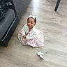 bow, cardigan, casual, child, couch, cute, dress, floor, furniture, girl, hair_bow, happy, indoor, playful, sitting, small_child, smiling, toddler, white_shoe, wooden_floor